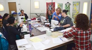 Photo of group of women at 2017 Envrionment grantee ReUse works with sewing machines