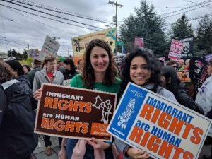Photo of women with Northwest Immigrant Rights Project protest sign